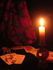 immagine che ritrae una candela accesa che illumina alcune carte degli arcani